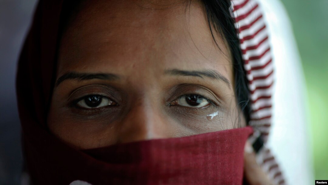 A Pakistani refugee, a member of the Ahmadiyya, an Islamic minority sect, cries as she leaves a detention centre with her family on a bus in Bangkok June 6, 2011. A group of 94 refugees and two asylum seekers from Pakistan, all members of the Ahmadiyya, w