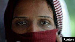 A Pakistani refugee, a member of the Ahmadiyya, an Islamic minority sect, cries as she leaves a detention centre with her family on a bus in Bangkok June 6, 2011. A group of 94 refugees and two asylum seekers from Pakistan, all members of the Ahmadiyya, w