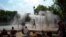 People cool off under a fountain along the Canal de l'Ourcq in Paris, France.