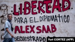 Un homme passe devant un graffiti indiquant "Liberté pour le diplomate Alex Saab, séquestré par le gouvernement du Cap-Vert" à Caracas, le 23 février 2021.