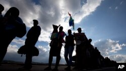 People are silhouetted against a late afternoon sun as they queue to see the remains of Nelson Mandela at the Union Buildings in Pretoria, South Africa, Dec. 11, 2013, where his body lies in state for three days.