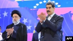 El presidente venezolano Nicolás Maduro aplaude durante un acto oficial en Caracas junto al presidente de Irán Ebrahim Raisi, el 13 de junio de 2023. Raisi falleció en un accidente de helicóptero, según medios de su nación.