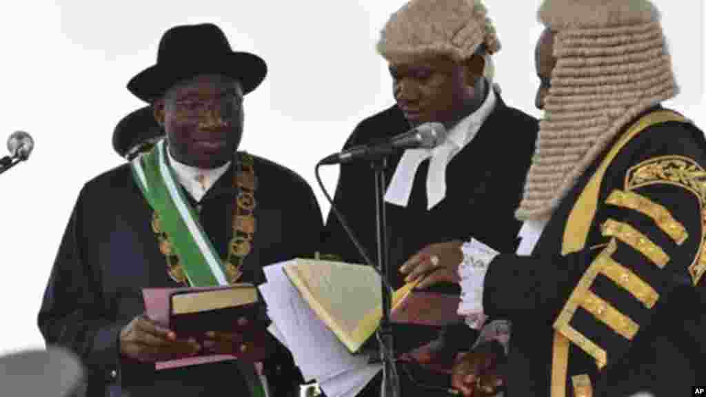 Nigerian President Goodluck Jonathan, left, takes the oath of office before Justice Sunday Olorundanusi, center, and Chief Justice of Nigeria Katsina Alu.