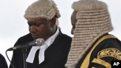 Nigerian President Goodluck Jonathan, left, takes the oath of office before Justice Sunday Olorundanusi, center, and Chief Justice of Nigeria Katsina Alu during his inauguration ceremony at the main parade ground in Nigeria's capital of Abuja Sunday, May 