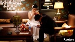 Sepasang pengantin menunggu berlangsungnya pernikahan massal di Shanghai. (Foto: Dok)