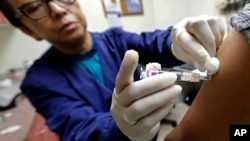 Ana Martinez, seorang asisten medis di Sea Mar Community Health Center, memberi suntikan anti flu kepada seorang pasien, Kamis, 11 Januari 2015 di Seatlle (foto: AP Photo/Ted S. Warren).