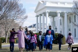 第一夫人吉尔·拜登陪着华盛顿艾顿小学的孩子参观白宫北草坪展示的情人节装饰。(2022年2月14日)
