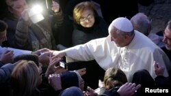 Pope Francis greets the faithful as he arrives to visit the Church of St Alfonso Maria dei Liguori in the outskirts of Rome Jan. 6, 2014.