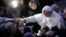 Pope Francis greets the faithful as he arrives to visit the Church of St Alfonso Maria dei Liguori in the outskirts of Rome Jan. 6, 2014.