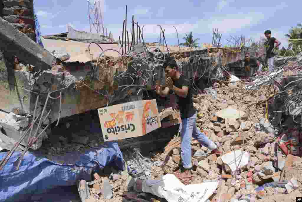 Warga memindahkan sekardus makanan dari bawah puing-puing bangunan yang ambruk akibat gempa di Pidie Jaya, Aceh (7/12).&nbsp;(AP/Heri Juanda)