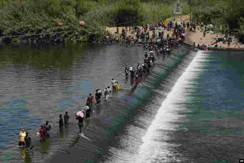 Haitian migrants use a dam to cross into the United States from Mexico, Sept. 18, 2021, in Del Rio, Texas.