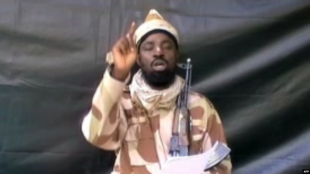 FILE - A grab made on July 13, 2013 from a video obtained by AFP shows the leader of the Islamist extremist group Boko Haram Abubakar Shekau, dressed in camouflage and holding an Kalashnikov AK-47. 