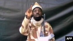 FILE - A grab made on July 13, 2013 from a video obtained by AFP shows the leader of the Islamist extremist group Boko Haram Abubakar Shekau, dressed in camouflage and holding an Kalashnikov AK-47. 