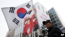 An anti-communist person holds a national flag during a rally to celebrate the victory of South Korea's president-elect Park Geun-hye of Saenuri Party in front of the party headquarters in Seoul, South Korea, December 20, 2012.