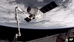 Esta imagen proporcionada por NASA-TV muestra la nave espacial de carga Dragón SpaceX cuando es capturada por el brazo robótico de la Estación Espacial.