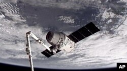 Esta imagen proporcionada por NASA-TV muestra la nave espacial de carga Dragón SpaceX cuando es capturada por el brazo robótico de la Estación Espacial.