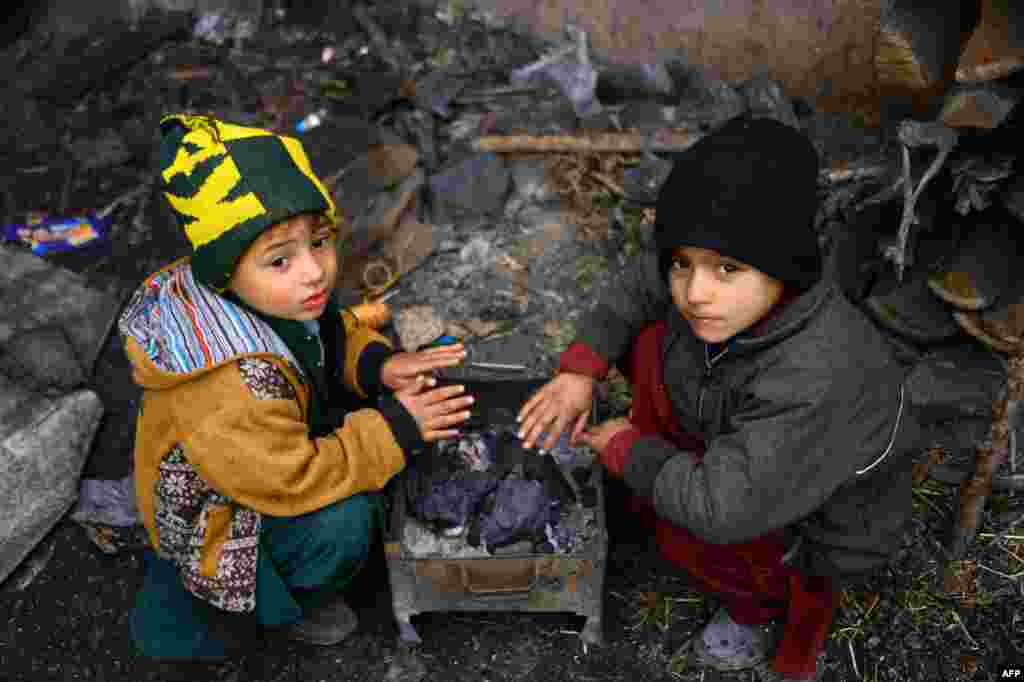 Children warm up themselves around a charcoal fire in Herat, Afghanistan.