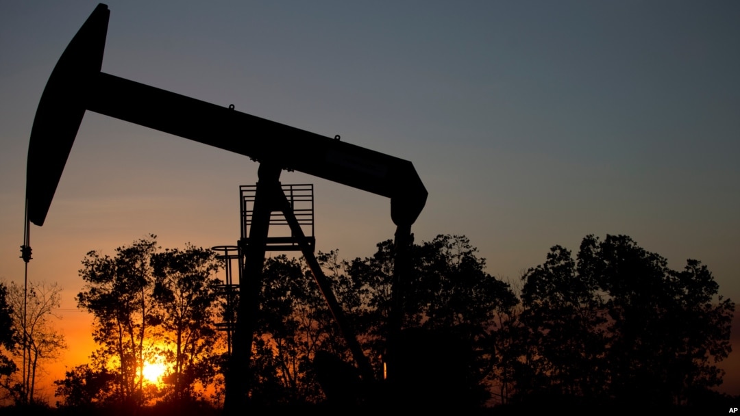 In this Feb. 19, 2015 photo, the sun sets behind an oil well in a field near El Tigre, a town within Venezuela's Hugo Chavez oil belt, formally known as the Orinoco Belt.