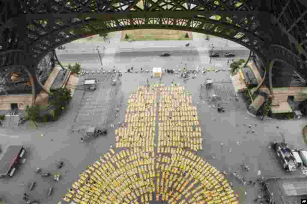 Thousands of participants dressed in white performing yoga on yellow mattresses are pictured from the first floor of the Eiffel Tower at an event to celebrate the International Yoga Day in Paris, France, Sunday, June 21, 2015. Thousands of yoga enthusiast