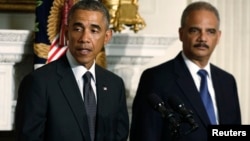 U.S. President Barack Obama (L) announces the resignation of Attorney General Eric Holder (R) in the White House State Dining Room in Washington, Sept. 25, 2014.