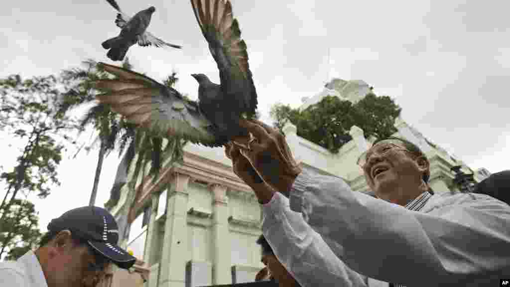 Warga melepaskan burung-burung merpati bagi perdamaian di Kuil Erawan yang baru saja menjadi sasaran pengeboman di Bangkok, Thailand.