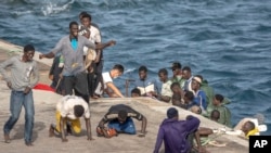 ARCHIVO – Un grupo de migrantes reacciona al llegar al puerto de La Restinga, en El Hierro, islas Canarias, España, el 19 de agosto de 2024.