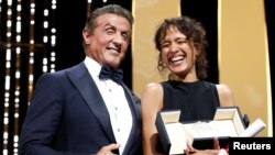 La réalisatrice Mati Diop recevant le Grand Prix pour son film "Atlantique", aux côtés de Sylvester Stallone au 72e Festival de Cannes, France, le 25 mai 2019.