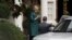 FILE - Then-Democratic presidential candidate Hillary Clinton uses her smartphone as she leaves her home in Washington, Oct. 5, 2016.