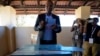 Umbrella for Democratic Change (UDC) presidential candidate Duma Boko holds his ballot paper before inserting it into the box during the elections in Gaborone, Botswana, Oct. 30, 2024. 