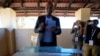 Umbrella for Democratic Change (UDC) presidential candidate Duma Boko holds his ballot paper before inserting it into the box during the elections in Gaborone, Botswana, Oct. 30, 2024. 