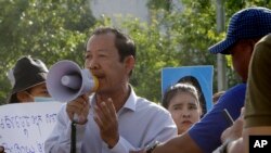 Rong Chhun, presiden Konfederasi Serikat Pekerja Kamboja, menggunakan megafon saat berlangsungnya aksi protes di dekat kediaman perdana menteri Hun Sen di Phnom Penh, 29 Juli 2020. (Foto: dok). 