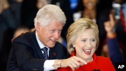 FILE - Former President Bill Clinton, left, and Democratic presidential candidate Hillary Clinton acknowledge supporters during a caucus night rally at Drake University in Des Moines, Iowa, Feb. 1, 2016.