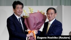 Japanski premijer Šinzo Abe i njegov naslednik Jošihide Suga posle izbora u Liberalno demokratskoj partiji