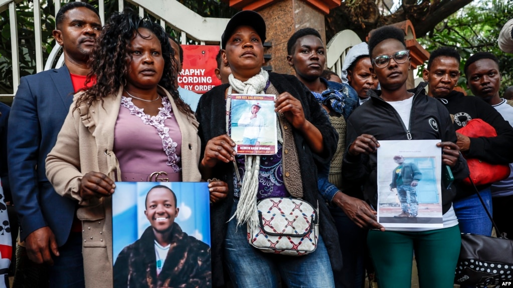 FILE - People hold photos of disappeared or deceased relatives in front of the president's office as they gather to present a list of people who disappeared during demonstrations against government-proposed tax hikes, in Nairobi, Kenya, Sept. 24, 2024.