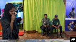 Bangladeshi policemen guard outside a shutdown stall of "Badwip Prokshan," a publishing house at a major month-long book fair in Dhaka, Bangladesh, Feb.16, 2016.