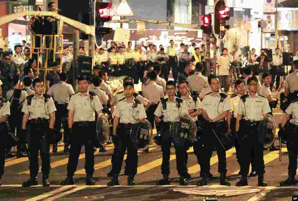 Riot police prepare to confront pro-democracy students as they clear their encampment in the Mong Kok district of Hong Kong, early Friday, Oct. 17, 2014.