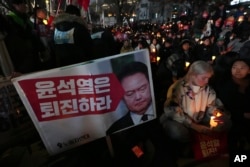 People hold candles during a candlelight vigil against South Korean President Yoon Suk Yeol in Seoul, South Korea, Dec. 4, 2024.