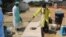 An official disinfects a bed for patients at a temporary shelter in Harare, Sept. 12, 2018, where suspected cholera patients are being treated. (C. Mavhunga/VOA)