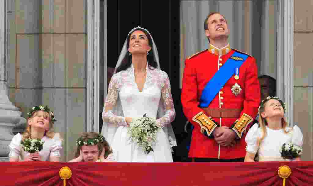 Prince William and his wife watch a fly-past of military planes from the balcony following the wedding. (AP Photo/Matt Dunham)