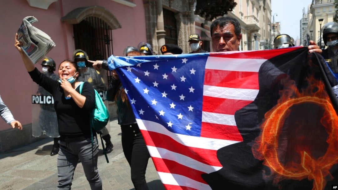 Prosvjednici protiv peruanskog predsjednika Martina Vizcarre, koji se suočava s opozivom, nose američku zastavu s slovom Q, pozivajući se na QAnon, u blizini Kongresa u Limi, Peru, 9. novembra 2020.