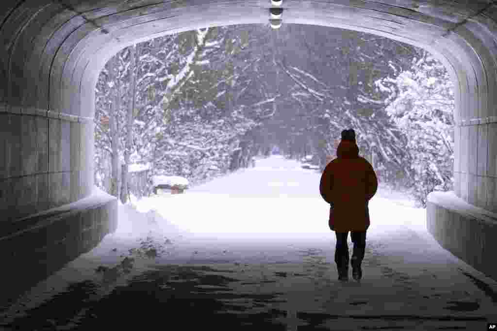 Un peatón camina por un túnel a lo largo del sendero Monon Trail cubierto de nieve en Carmel, Indiana.