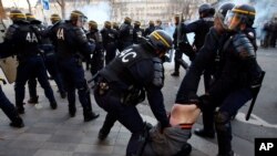 Riot Police officers apprehend a protester during clashes at a demonstration against alleged police abuse, in Paris where anti-racism groups and other activists gathered in support of victims of police violence. 