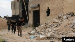 Free Syrian Army fighters run with their weapons during clashes with forces loyal to Syria's President Bashar al-Assad at the Karam Barre front line in Aleppo, Nov. 2, 2014. 