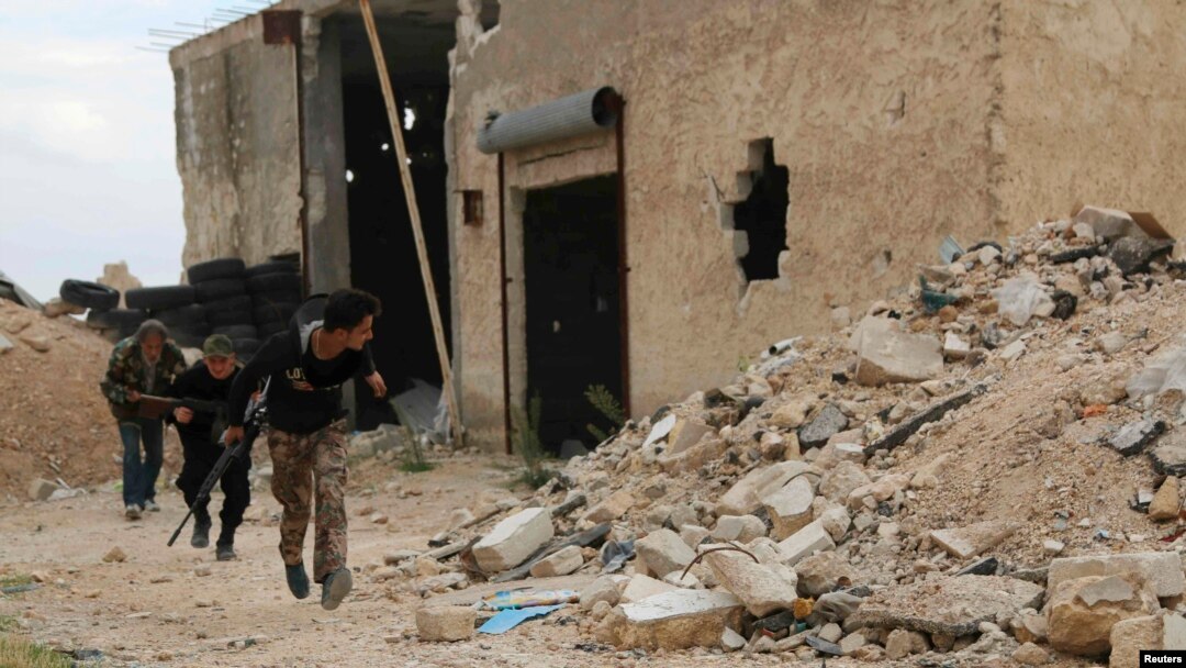 Free Syrian Army fighters run with their weapons during clashes with forces loyal to Syria's President Bashar al-Assad at the Karam Barre front line in Aleppo, Nov. 2, 2014. 