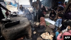 FILE - Palestinian women make break in ovens at a makeshift camp housing displaced Palestinians, in Rafah in the southern Gaza Strip, amid the ongoing conflict between Israel and the militant group Hamas, on January 2, 2024.