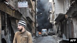 Seorang pria Suriah berjalan melalui kawasan Salahedin yang semula diduduki oleh pemberontak ddi utara kota Aleppo (AFP PHOTO / George OURFALIAN).