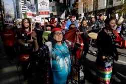 People taking part in a rally to mark Indigenous Peoples' Day in downtown Seattle sing as they march toward Seattle City Hall, Monday, Oct. 14, 2019. The observance of the day was made official by the Seattle City Council in 2014.