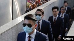 Des policiers de Hong Kong arrivent au tribunal de district de Hong Kong, le 14 février 2017, alors qu'ils étaient accusés d'avoir agressé un militant en faveur de la démocratie lors d'un incident le 15 octobre 2014. AP / Kin Cheung