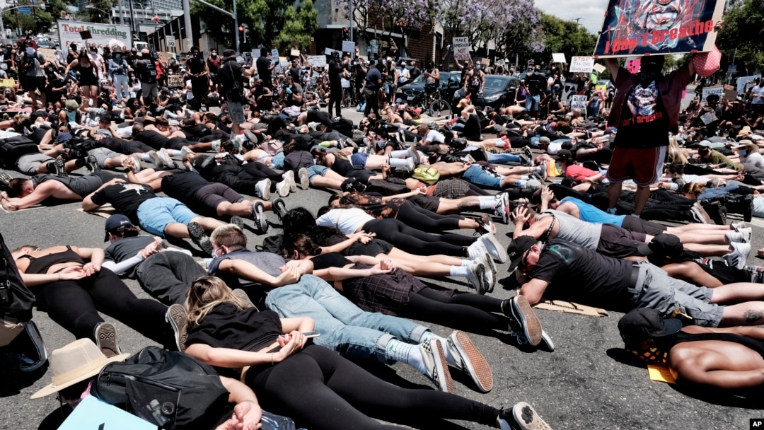 LGBTQ community members join Black Lives Matter protesters as they block an intersection laying on the street with their hands behind their backs in West Hollywood, Calif., on June 3, 2020, over the death of George Floyd. 