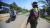 Un guerrillero de las FARC-EMC hace guardia en una carretera en un puesto de control en Corinto, Colombia, el viernes 12 de abril de 2024, el día después de que un coche bomba explotara en la cercana ciudad de Miranda.